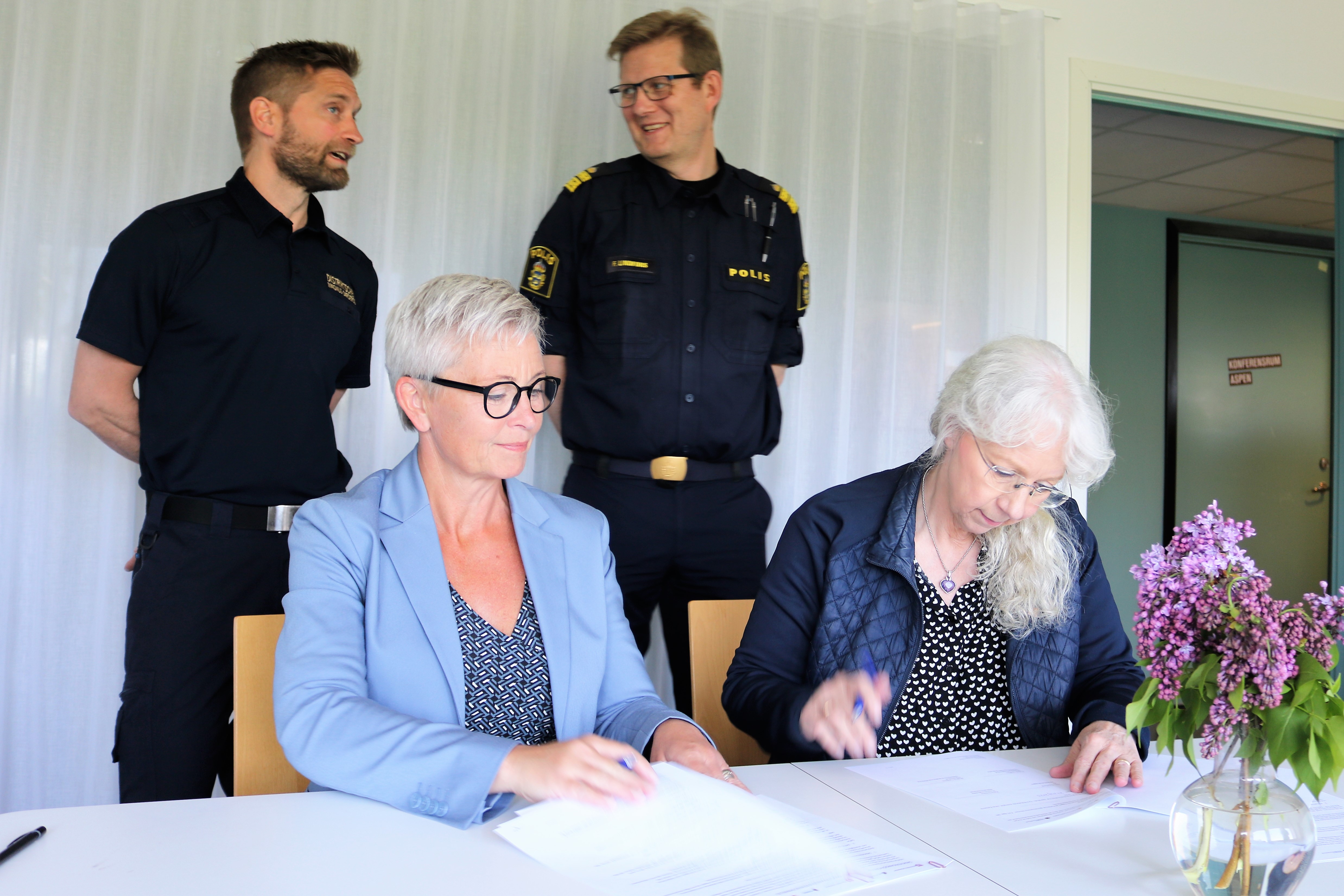 tre personer skriver under avtal 