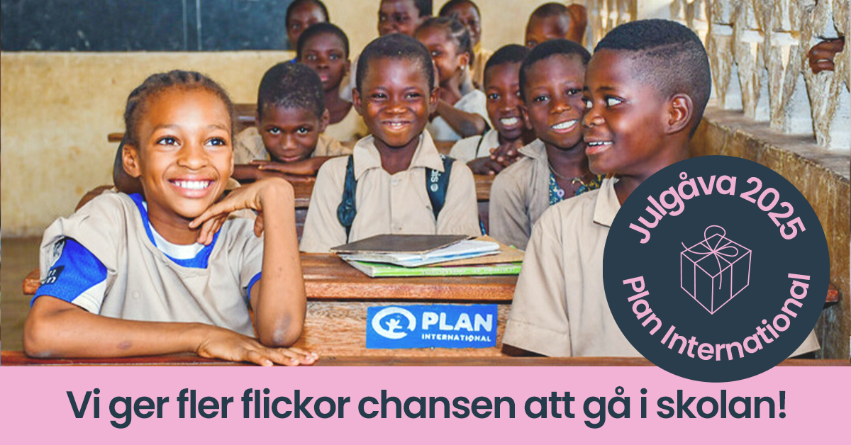 En grupp med skolbarn sitter i ett klassrum. De ser glada ut.