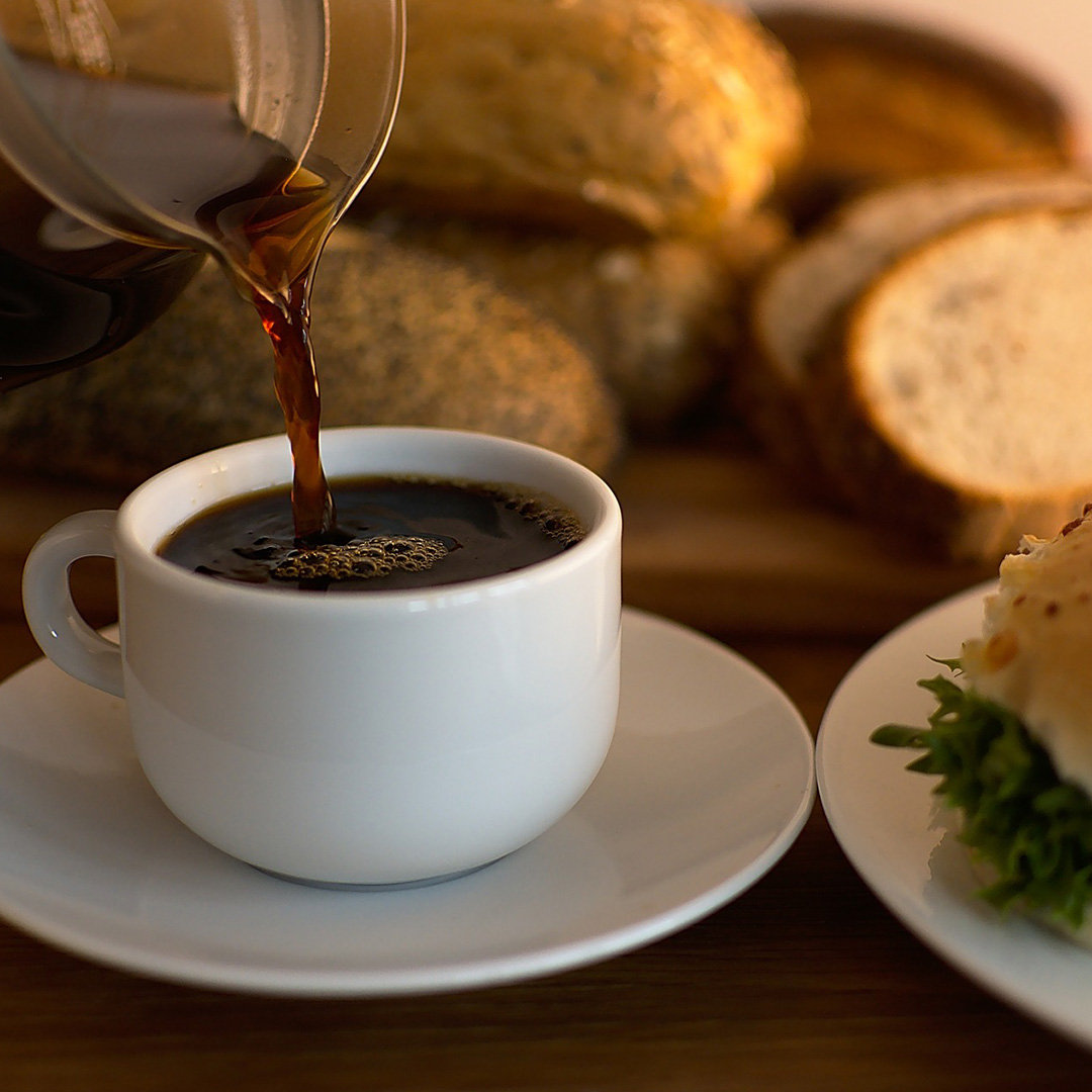 Kaffe hälls upp i en vit kaffekopp