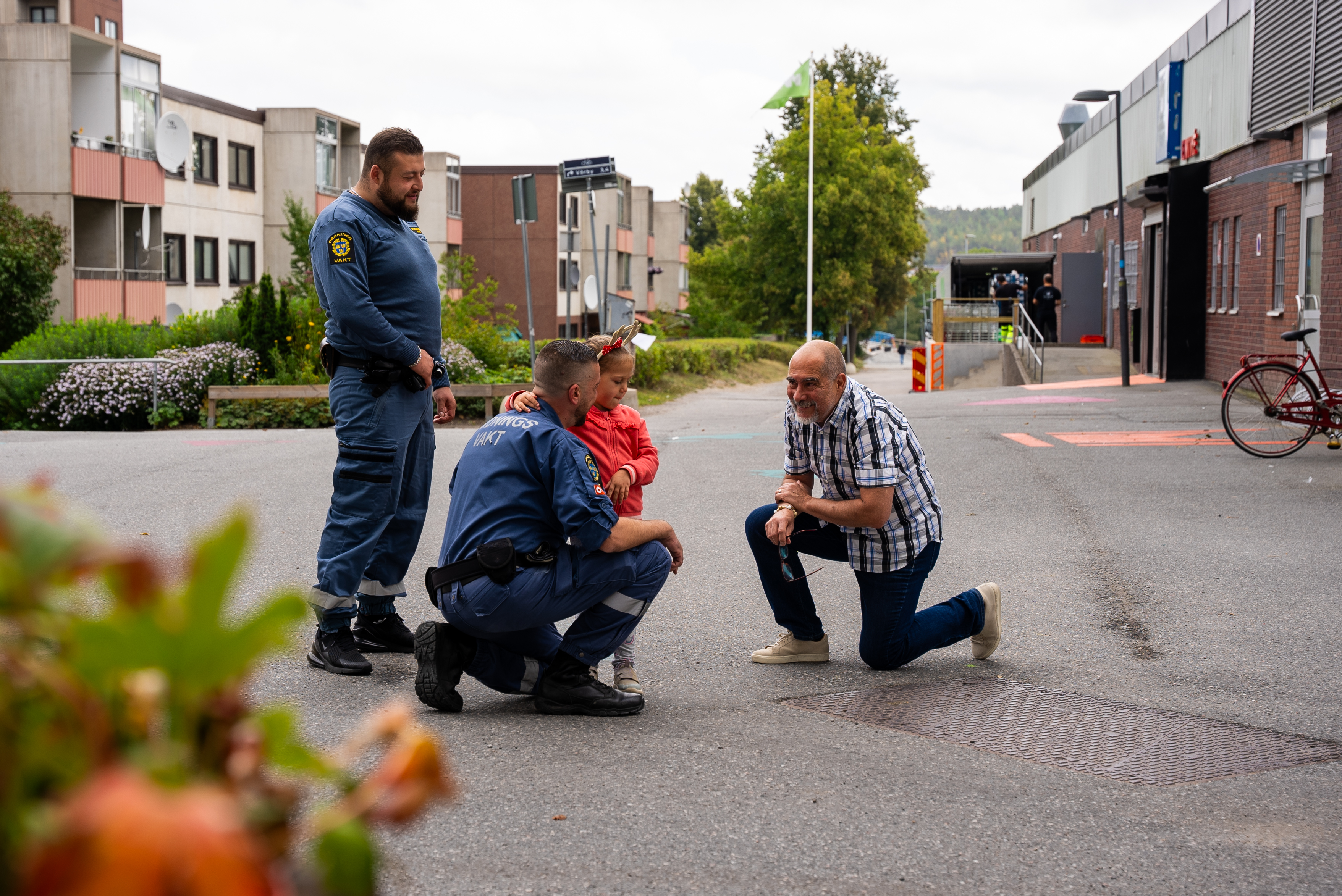 Två ordningsvakter pratar med en flicka och en man i Fittja