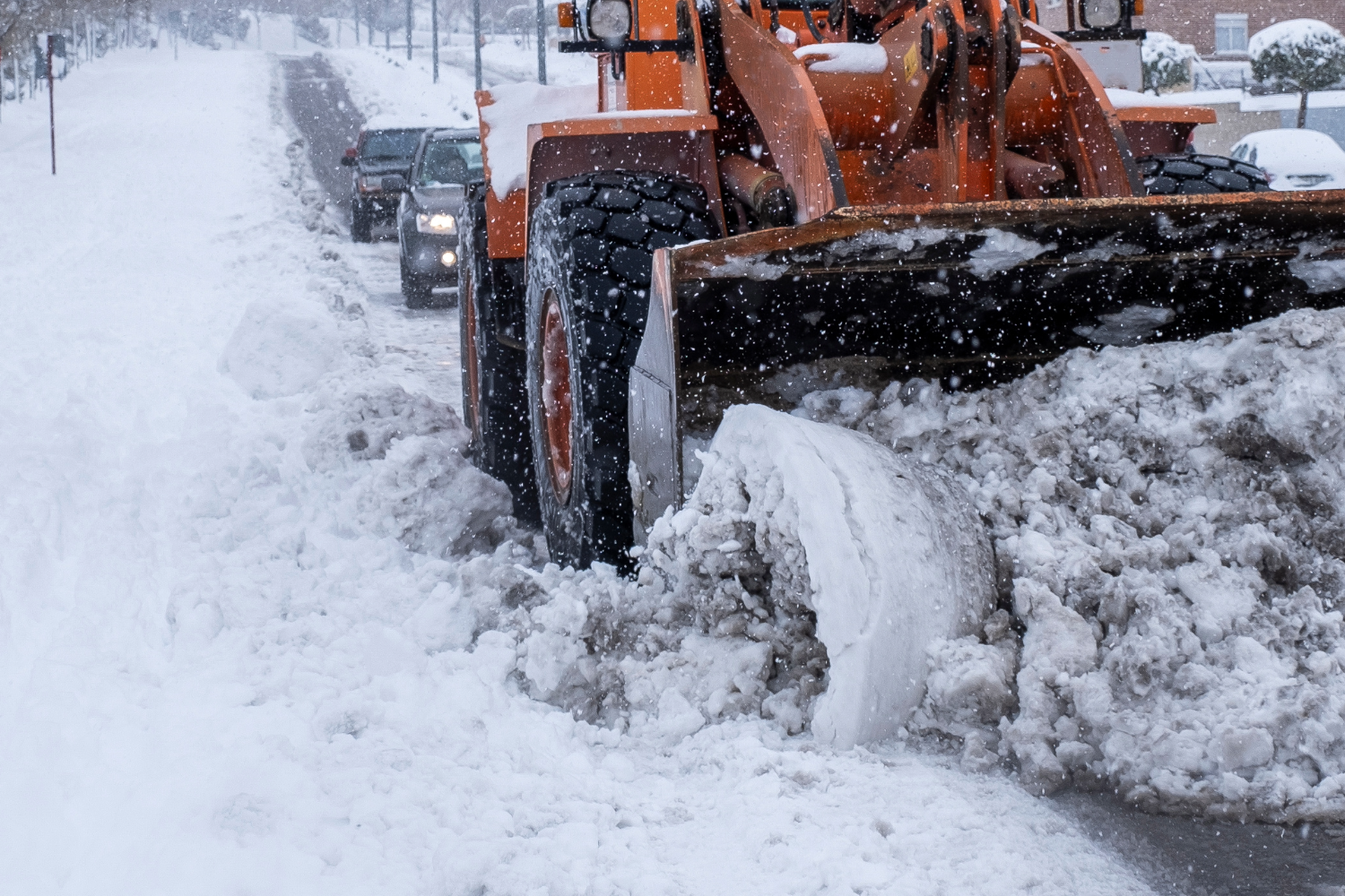 En gul traktor plogar en väg