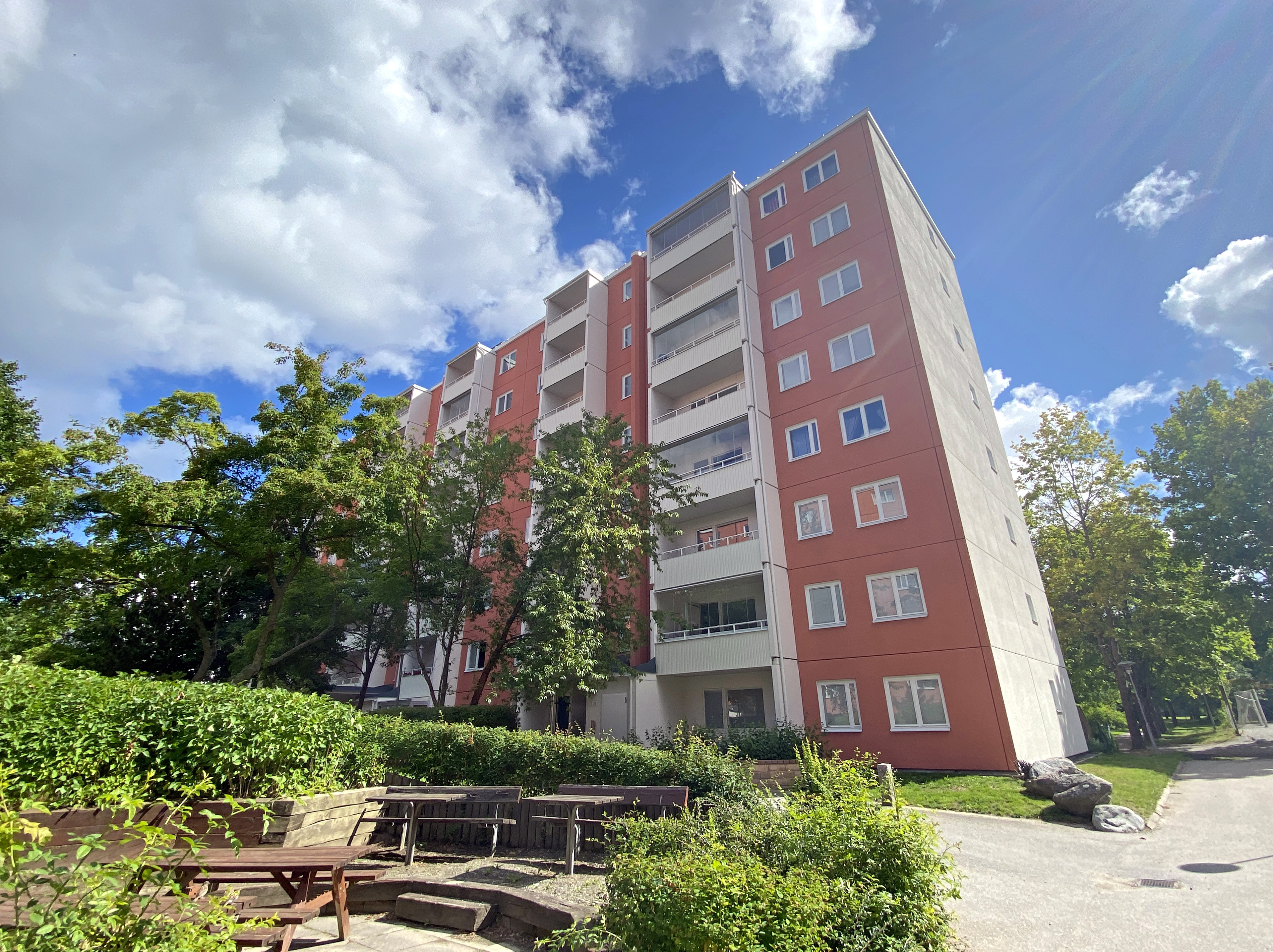 Ett rött högvåningshus mot en blå himmel.