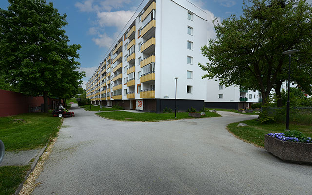 Ett flerbostadshus i vitt med gula balkonger
