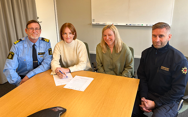 Fyra personer sitter vid ett konferensbord